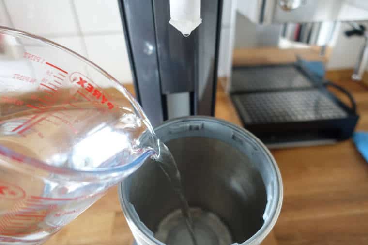 Wasser/Zitronensäure Gemisch in den Flaschenkorb kippen